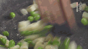 鍋中油7成熱時(shí)，入青豆、筍丁翻炒，然后加糯米飯加鹽均勻翻炒。