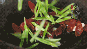 先后下香腸片、四季豆絲均勻翻炒，加適量清水燜煮一下。