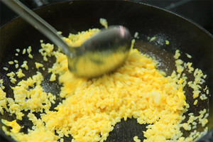 大火加熱炒鍋，再入油，燒到四至五成熱時倒入雞蛋液，在未凝結(jié)之前，加米飯煸炒，不停翻炒并用鍋鏟將成塊的米飯碾開、撥散。