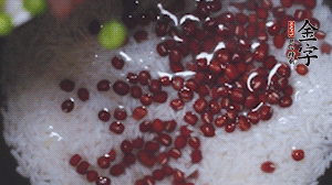 將炒好的食材和大米、紅豆一起放進(jìn)電飯鍋煮。