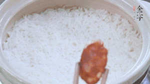 煮開后轉(zhuǎn)小火，當(dāng)米飯出現(xiàn)小孔時，鋪上金字麻辣香腸。