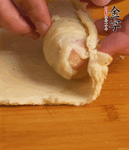 吐司卷起香腸，吐司尾端涂抹少許全蛋液，卷好的吐司表面蘸上蛋液，在裹上一層面包糠，送入預(yù)熱好的烤箱中。