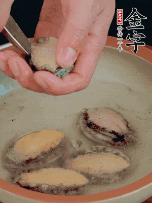 鮑魚加鹽、清水浸泡，用勺子挖出鮑魚肉。