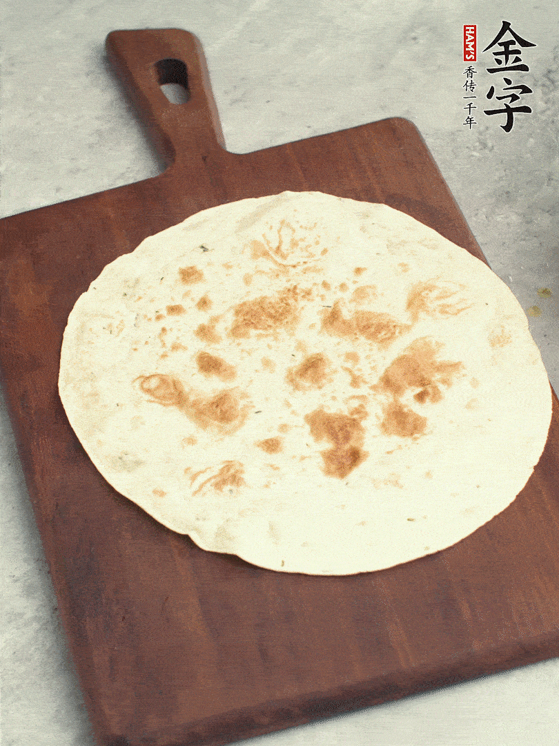 食材依次鋪在卷餅皮上，卷起來。