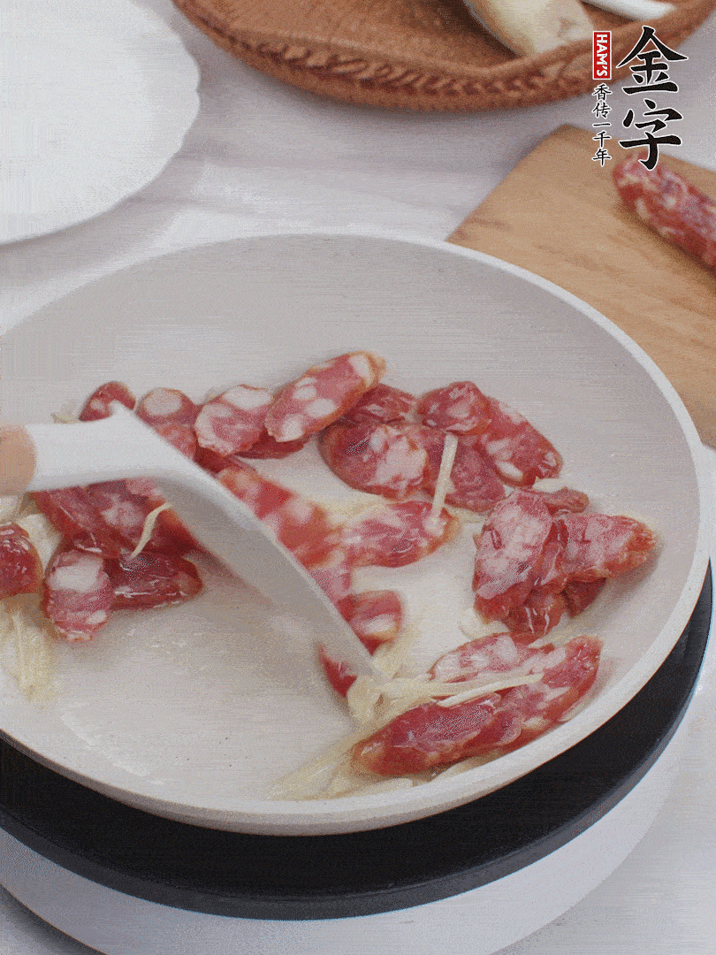 油溫3成熱時(shí)，下姜絲、蒜片、香腸炒出油脂。