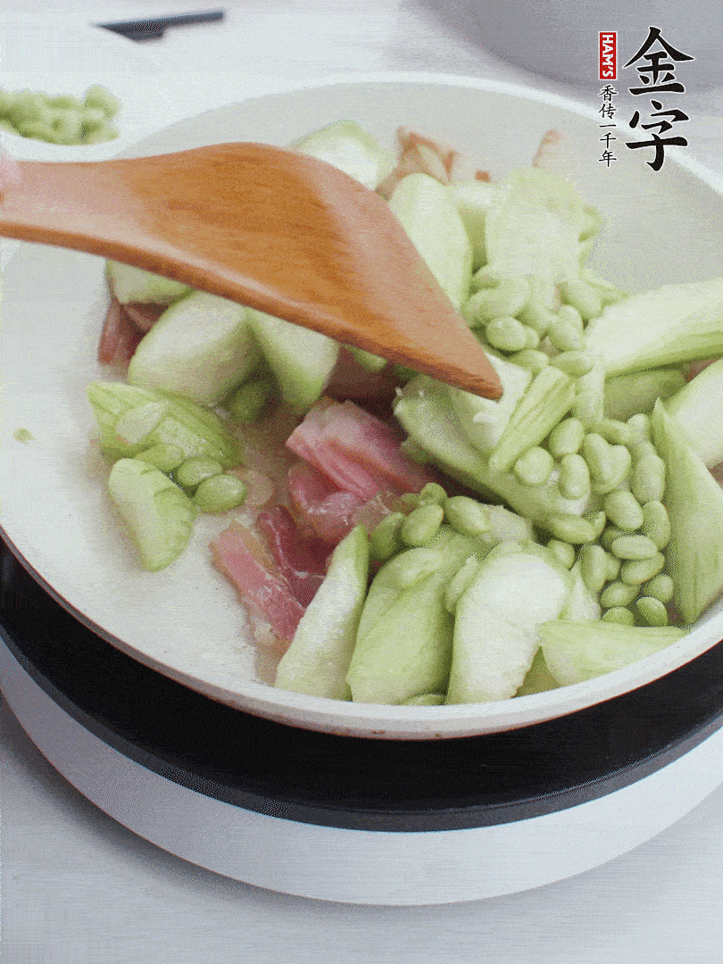 依次下絲瓜、青豆翻炒，炒至絲瓜打蔫縮小。
