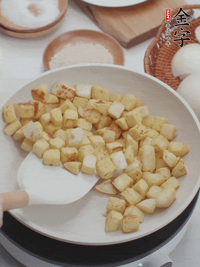 起鍋熱油，倒入饅頭丁，小火煎至蛋液凝固定型再翻面，饅頭丁部煎至金黃時盛起待用。