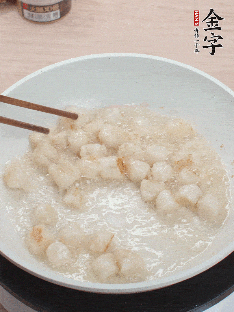 油溫4成熱，鮮貝蘸干淀粉下鍋煎，一面微黃后翻面。