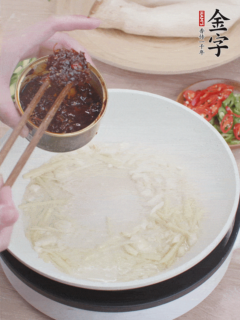 起鍋熱油，姜蒜、金字火腿干貝醬煸香。