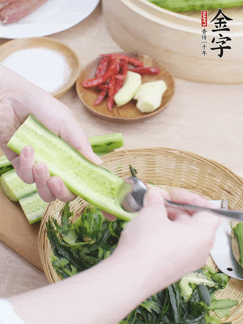 黃瓜削皮，對半切開，勺子挖去內(nèi)瓤，斜刀切片。青蒜斜刀切段。