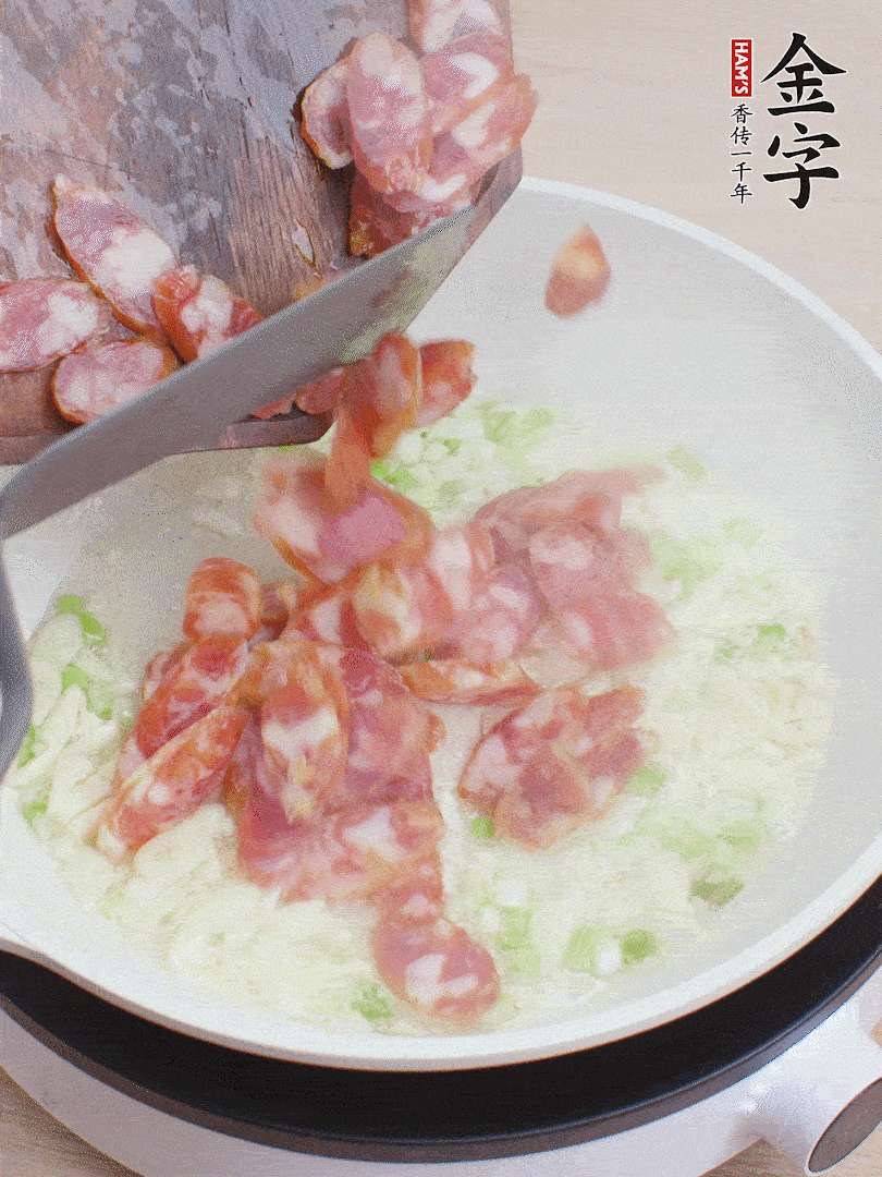 油5成熱，蒜末、蔥白爆香，下香腸炒出香味。