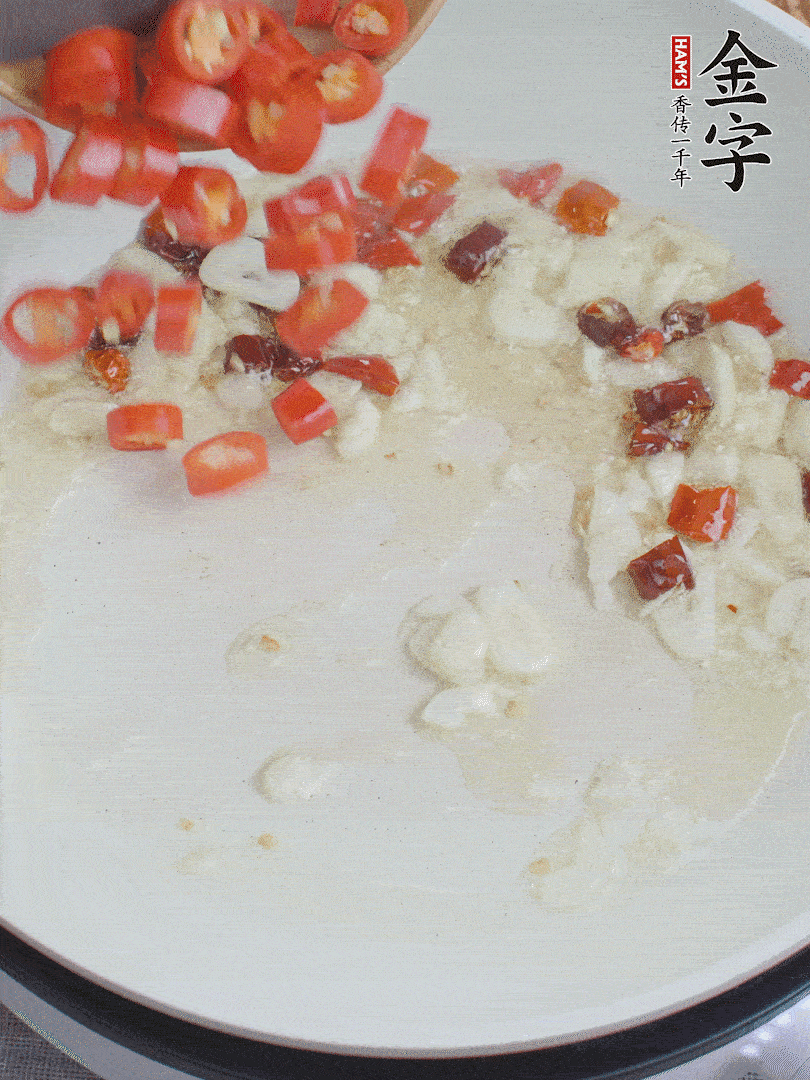 油6成熱，下蒜末、干紅辣椒煸炒，出香味后再放美人椒、香腸。