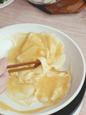 油6成熱時，下雞蛋液，邊緣凝固時翻拌成塊狀。