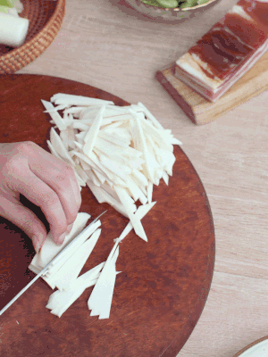 茭白切細(xì)絲，鹽水中浸泡防止氧化。