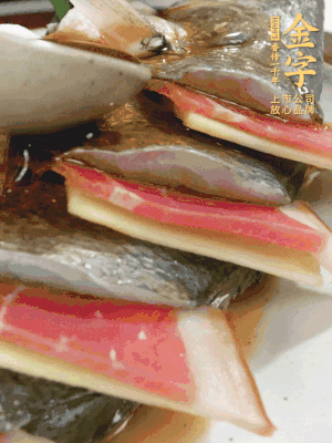 魚肚中塞蔥結(jié)、火腿片，魚身上碼放姜片、火腿片，倒入混合的料汁。