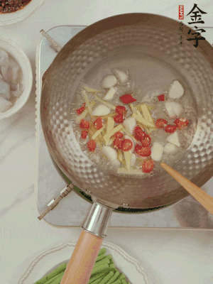 油7成熱時，下大蒜粒、姜絲、小米辣煸香。