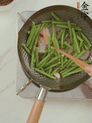 下掰好的缸豆段翻炒，略燜煮。