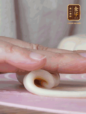 做面劑 油皮按扁，中間包入一個油酥，邊緣收緊捏死。包好的面劑按扁，用搟面杖搟壓成橢圓形。從底部向上卷成筒狀，用保鮮膜蓋好松弛15分鐘，再把筒狀縱向搟壓成長條狀。再卷一次，松弛20分鐘