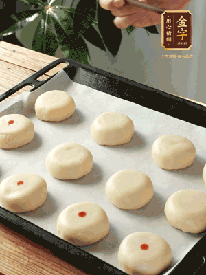 收口向下放在案板上，輕輕將月餅坯按扁，用筷子點紅點做裝飾