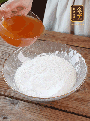 轉(zhuǎn)化糖漿、枧水、花生油攪拌均勻，加入面粉混合，醒發(fā)2小時。捏成23g一個的小球