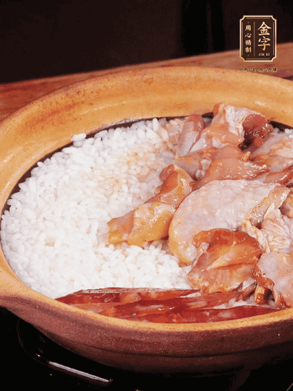 煮到椰子水微微收干轉(zhuǎn)小火，快速均勻鋪上雞肉、金字香腸